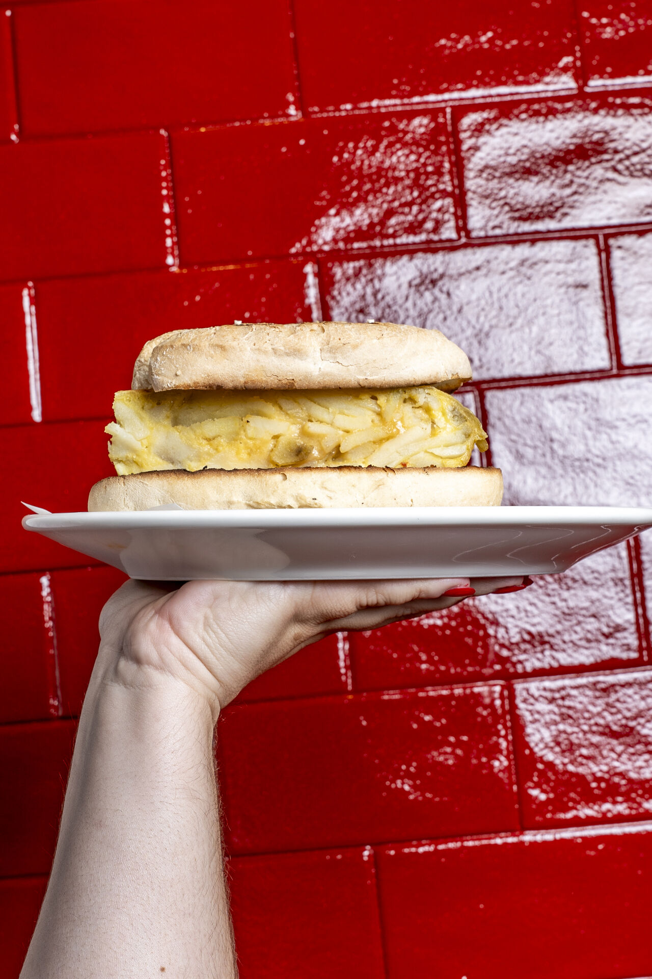 Bocata de tortilla a la brasa sobre azulejo rojo